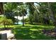 Expansive backyard with mature trees, lush grass, and tranquil waterway view at 7301 Ballantrae Pl # 27D, Sarasota, FL 34238