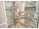 Large walk-in shower with marble tile and pebble floor at 7301 Ballantrae Pl # 27D, Sarasota, FL 34238