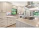 Modern kitchen with stainless steel appliances, white cabinets, and quartz countertops at 7301 Ballantrae Pl # 27D, Sarasota, FL 34238