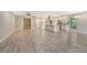 Open living room featuring light grey wood-look flooring and an open concept to the kitchen at 7301 Ballantrae Pl # 27D, Sarasota, FL 34238