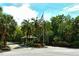 Community entrance with gated access, lush landscaping, and American flag at 7301 Ballantrae Pl # 27D, Sarasota, FL 34238