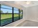 Bedroom with large windows overlooking a tranquil backyard at 7301 Ballantrae Pl # 27D, Sarasota, FL 34238