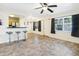 Open living room with tile floors, kitchen bar, and ceiling fan at 4805 Rilma Ave # 104, Sarasota, FL 34234