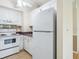White kitchen appliances and cabinetry, with view into adjacent dining area at 4800 Rilma Ave # 143, Sarasota, FL 34234