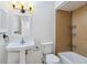 Clean bathroom with pedestal sink, shower/tub combo, and wood-look tile at 4800 Rilma Ave # 143, Sarasota, FL 34234