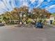 Front view of condo building with parking lot, landscaping, and mature trees at 4800 Rilma Ave # 143, Sarasota, FL 34234