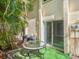 Small patio with a glass-top table next to sliding glass doors at 4800 Rilma Ave # 143, Sarasota, FL 34234