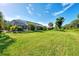 Large grassy backyard with lush landscaping and screened enclosure at 139 Long Meadow Lane Ln, Rotonda West, FL 33947