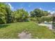 Large grassy backyard with mature trees and patio at 839 40Th St, Sarasota, FL 34234