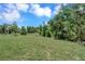 Large grassy backyard with mature trees bordering the property at 221 Evergreen St, Punta Gorda, FL 33982