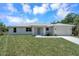 Single-story home with gray door and attached garage at 221 Evergreen St, Punta Gorda, FL 33982