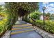 Steps lead up to a covered walkway with lush foliage overhead at 3245 Beneva Rd # 104, Sarasota, FL 34232