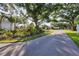 Landscaped entryway with mature trees and a curving path at 3245 Beneva Rd # 104, Sarasota, FL 34232