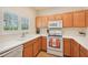 Galley kitchen with light wood cabinets and white countertops at 341 Cape Harbour Loop # 105, Bradenton, FL 34212
