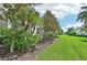 Landscaped backyard with lush green grass and mature trees at 341 Cape Harbour Loop # 105, Bradenton, FL 34212