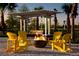 Relaxing fire pit area with yellow Adirondack chairs and pergola at 10112 Cross River Trl, Parrish, FL 34219