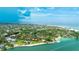 Aerial view of waterfront property with lush landscaping and private dock at 11 Sandy Cove Rd # 8-F, Sarasota, FL 34242