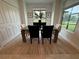 Bright dining area with a wooden table, four chairs, and ample natural light from two large windows at 17445 Opal Sand Dr # 104, Venice, FL 34293