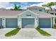 Garage doors and home number view, with attractive pavers and manicured landscaping at 17445 Opal Sand Dr # 104, Venice, FL 34293