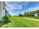 Beautiful golf course view from the side of a light gray residential building on a sunny day at 17445 Opal Sand Dr # 104, Venice, FL 34293