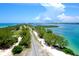 Breathtaking aerial view showcasing coastal road amidst lush greenery and stunning turquoise waters under a vibrant sky at 5111 Coral Blvd, Bradenton, FL 34210