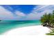 Picturesque beach scene featuring pristine white sand meeting crystal-clear turquoise waters under a sunny sky at 5111 Coral Blvd, Bradenton, FL 34210