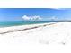 Expansive beach with white sand and clear turquoise water under a bright blue sky at 5111 Coral Blvd, Bradenton, FL 34210