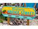 A colorful and whimsical Historic Bridge Street sign in a beach setting with palm trees at 5111 Coral Blvd, Bradenton, FL 34210