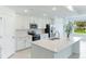 Modern kitchen with island, stainless steel appliances, and white cabinetry at 17445 Opal Sand Dr # 104, Venice, FL 34293