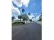 Asphalt driveway entrance with palm trees and white fence at 1499 17Th W St, Palmetto, FL 34221