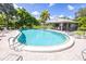 Relaxing kidney-shaped pool with lounge chairs and a covered patio at 3851 Wilshire Dr # 9, Sarasota, FL 34238