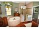 Primary bathroom with soaking tub, walk-in shower, and stained glass window at 2107 89Th St Nw, Bradenton, FL 34209