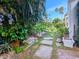 Landscaped side yard with stone pathway, tropical plants, and tranquil fountain at 2107 89Th St Nw, Bradenton, FL 34209