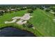 Aerial view of a lush green golf course with sand traps and a water feature at 7335 Saint Georges Way, University Park, FL 34201