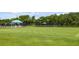Expansive croquet lawn with striped canopies and tennis courts at 7335 Saint Georges Way, University Park, FL 34201