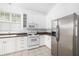 Modern kitchen with white cabinets, stainless steel appliances and tile flooring at 7335 Saint Georges Way, University Park, FL 34201