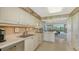 Modern kitchen with white cabinets and a view into the dining area at 826 Bayport Way # 826, Longboat Key, FL 34228