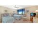 Bright bedroom with twin beds and a wicker sitting chair at 826 Bayport Way # 826, Longboat Key, FL 34228