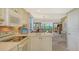 Kitchen with white cabinets, breakfast bar, and view of living area at 826 Bayport Way # 826, Longboat Key, FL 34228