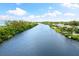 Aerial view of canal with lush vegetation and waterfront homes at 8016 Midnight Pass Rd, Sarasota, FL 34242