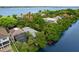 Aerial view of canal front property with lush landscaping at 8016 Midnight Pass Rd, Sarasota, FL 34242