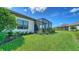 Lush backyard featuring a screened-in lanai and well-manicured lawn, perfect for outdoor living at 109 Corserra Dr, Nokomis, FL 34275
