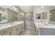 Modern bathroom featuring dual vanities, framed mirrors, sleek faucets, and a glass shower at 109 Corserra Dr, Nokomis, FL 34275