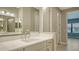 Bright bathroom featuring double vanity, framed mirror, lighting fixtures, and a view of a bedroom at 109 Corserra Dr, Nokomis, FL 34275