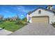 Well-maintained home with a tan garage door, manicured landscaping, and a brick paved driveway at 109 Corserra Dr, Nokomis, FL 34275