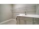 Well-lit laundry room with a utility sink, white countertops, and ample cabinet space at 109 Corserra Dr, Nokomis, FL 34275