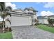 Two-story home with white exterior, paver driveway, and landscaped lawn at 12926 Pinnacle Ln, Venice, FL 34293