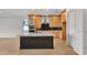 Modern kitchen with light wood cabinets, a large island, and dark base cabinets at 12926 Pinnacle Ln, Venice, FL 34293