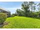 Large grassy backyard with mature trees and landscaping at 13791 Palmetto Point Ct, Port Charlotte, FL 33953