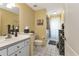 Bathroom features tiled floor, vanity, toilet, and shower behind curtain at 13791 Palmetto Point Ct, Port Charlotte, FL 33953